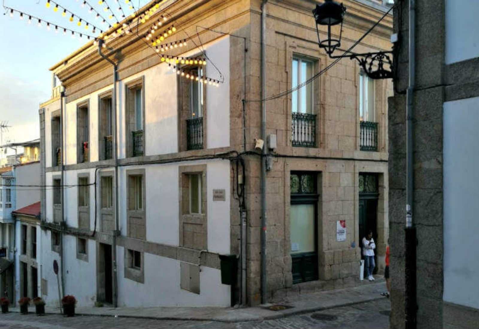 Steinernes Eckhaus in der Altstadt von Betanzos mit Lichterketten auf der Etappe nach Hospital de Bruma, Englischer Weg