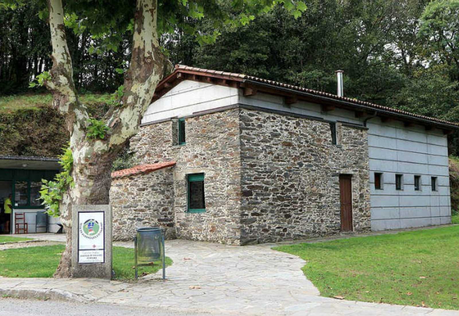 Steinerne Pilgerherberge in Hospital de Bruma mit Wegstein und einer Platane auf der Etappe von Betanzos, Englischer Weg