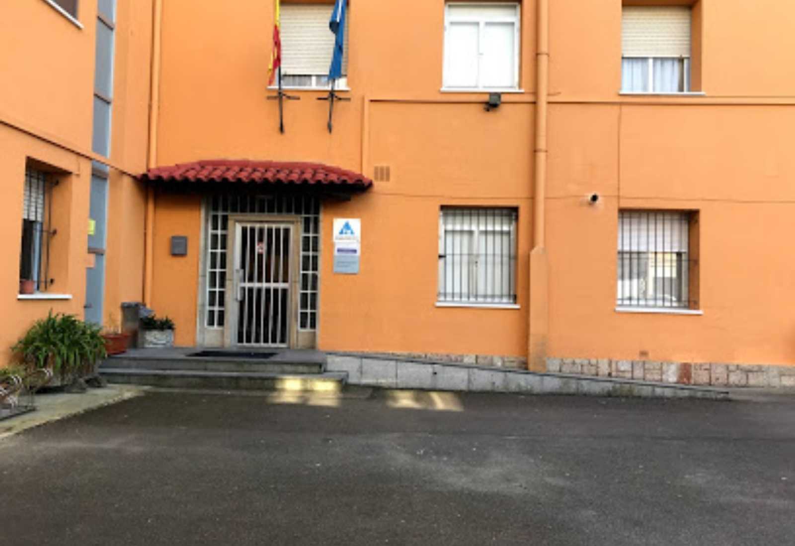Entrée de l'auberge de jeunesse de Llanes, bâtiment orange avec porche de tuiles et drapeaux, étape De Colombres à Llanes du Chemin du Nord.