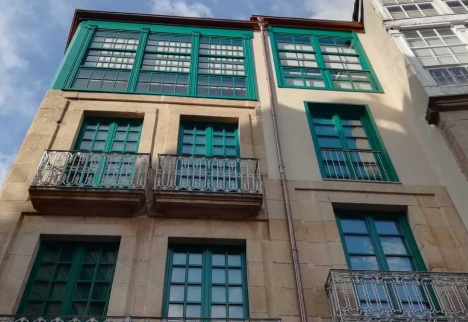Façade aux galeries vitrées vertes et balcons en fer forgé dans la vieille ville, étape du Chemin Sanabrés d'Ourense à Cea