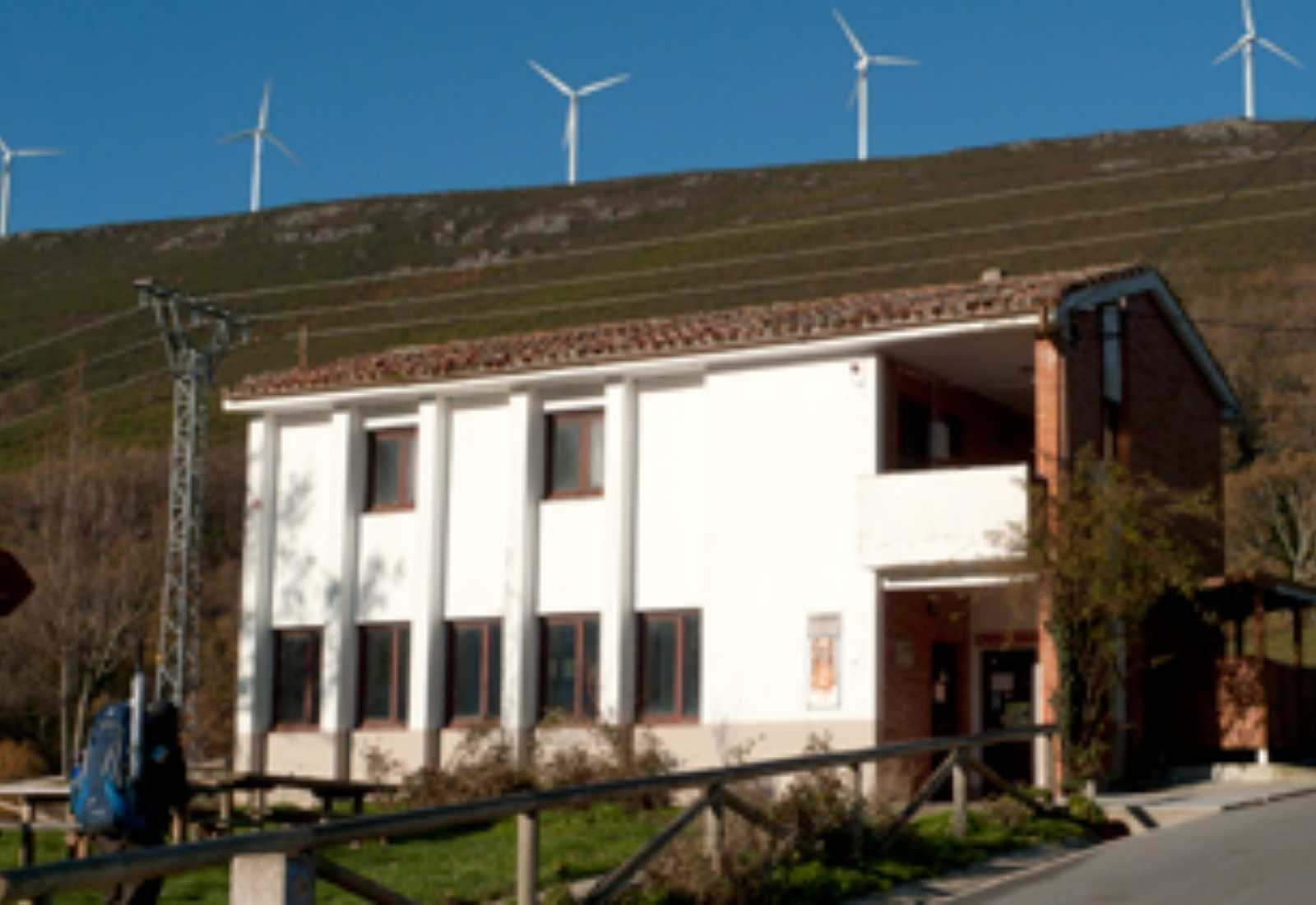 Albergue de peregrinos com aerogeradores na colina no início da etapa de La Mesa a Grandas de Salime do Caminho Primitivo