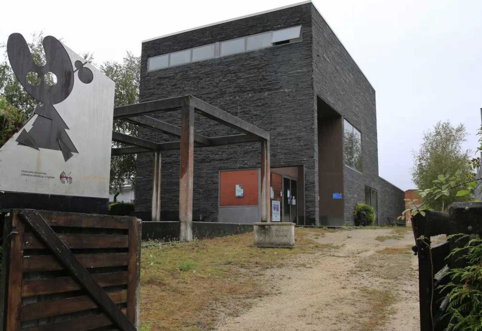 Gîte moderne revêtu d'ardoise avec un panneau sculptural à l'entrée, hébergement de l'étape du Camino del Norte à Vilalba.