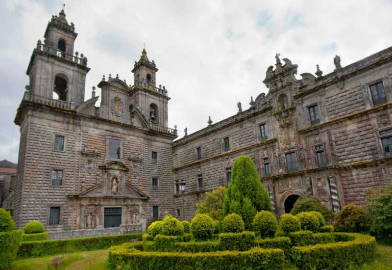 Monumental monasterio de Oseira con torres barrocas y jardines de setos recortados en la etapa de Cea a Lalín del Camino Sanabrés