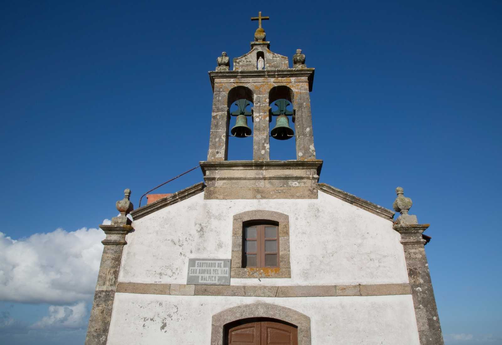 Ermita blanca con espadaña de dos campanas a la llegada a Malpica de Bergantiños en el Camino dos Faros