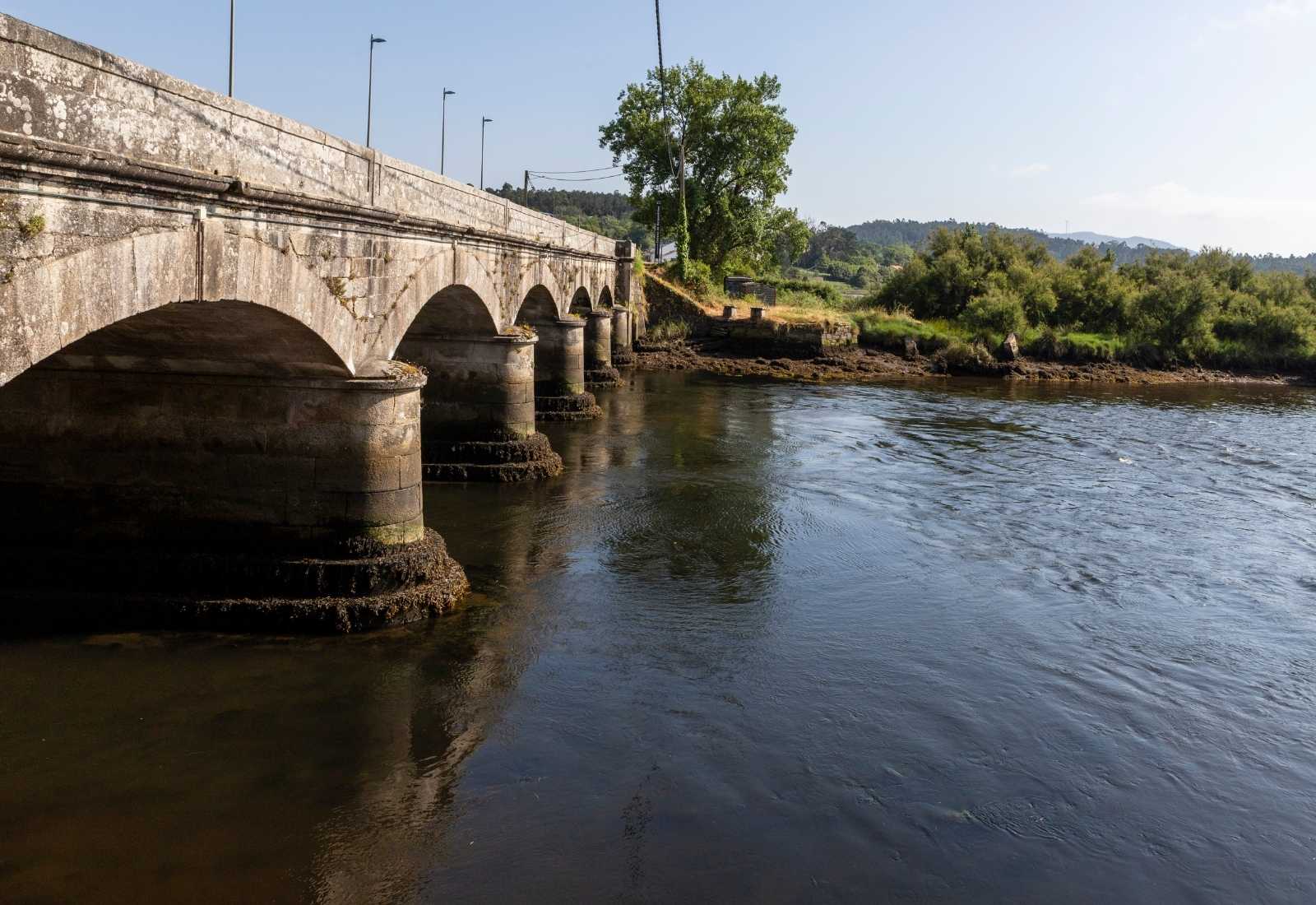Vieux pont de pierre à plusieurs arches sur la rivière sur l'étape de Playa de Niñóns à Ponteceso du Camiño dos Faros