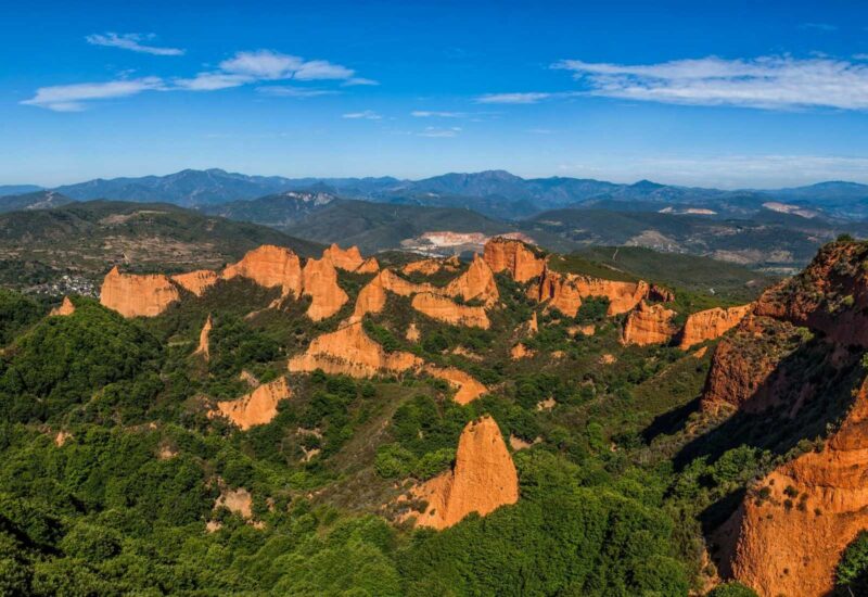 Le formazioni rossastre di Las Médulas tra boschi verdi nella tappa da Ponferrada a Carucedo del Camino de Invierno.
