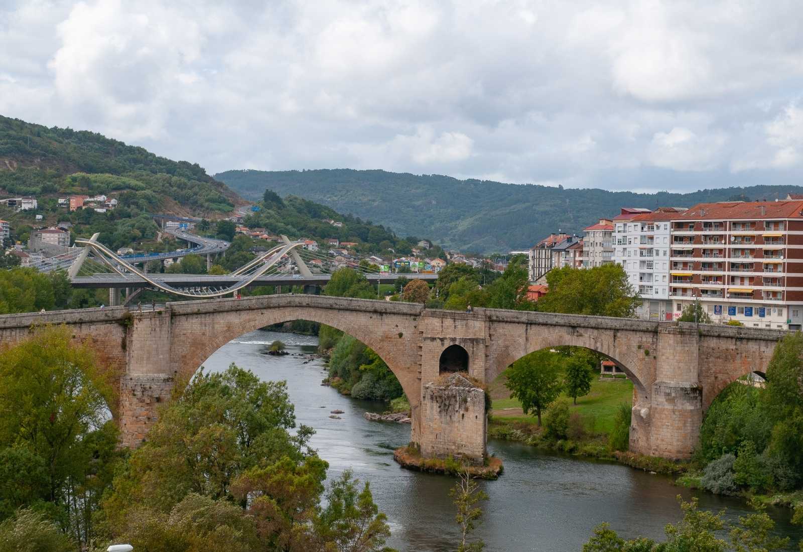 Pont médiéval en pierre sur la rivière à Ourense avec la ville en arrière-plan, étape d'Ourense à Cea.