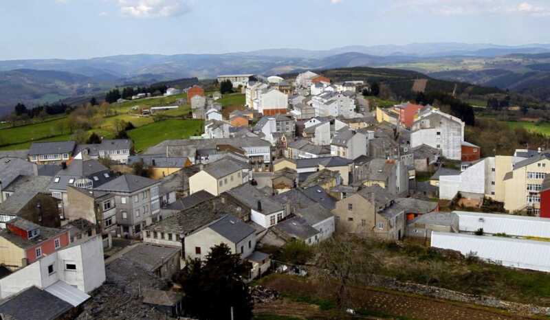 Vue en hauteur du village d'A Fonsagrada aux toits d'ardoise entre les collines, étape de A Fonsagrada à O Cádavo.