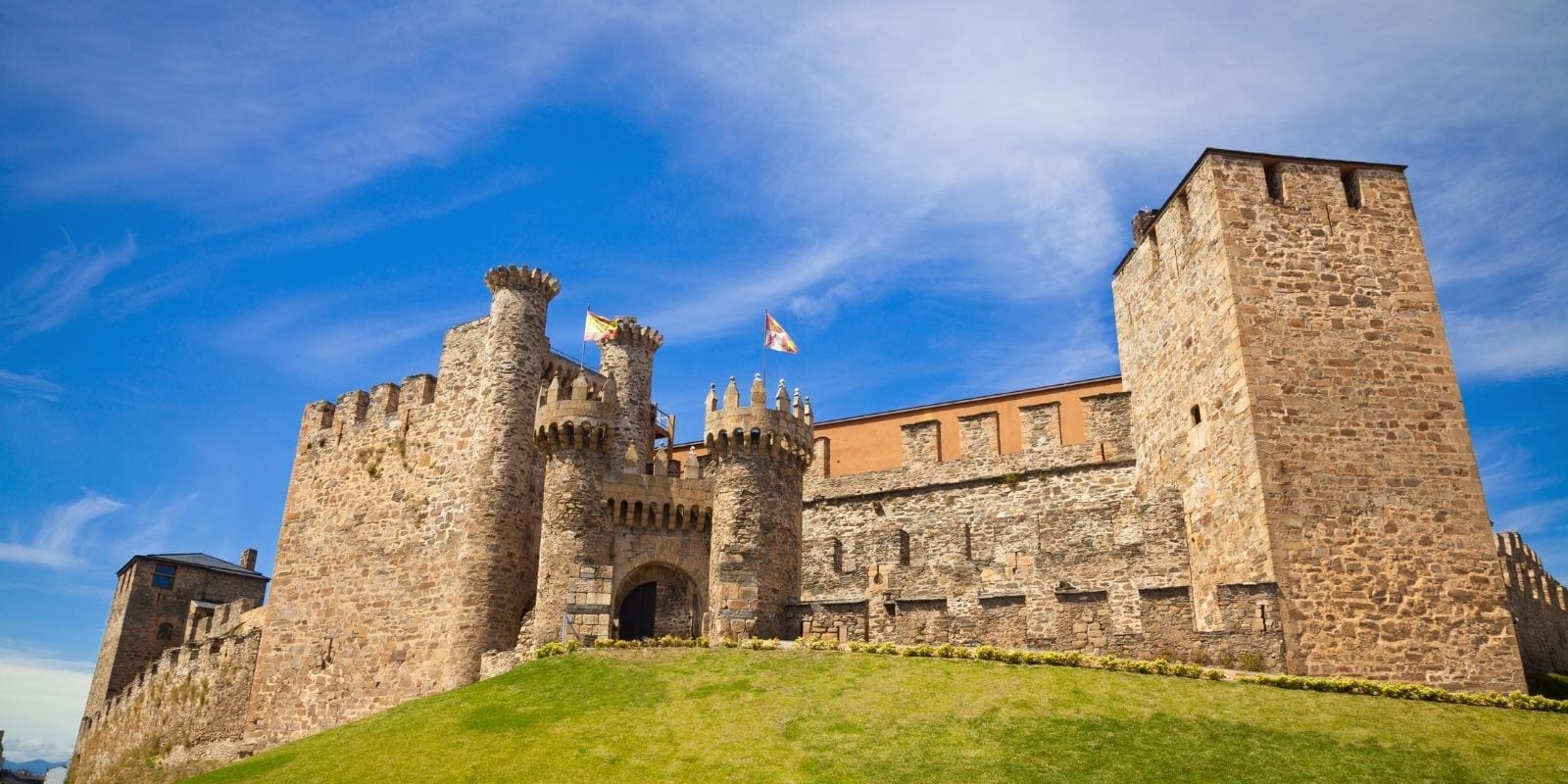 Il castello templare di Ponferrada con le torri merlate e le bandiere nella tappa da Ponferrada a Carucedo del Camino de Invierno.