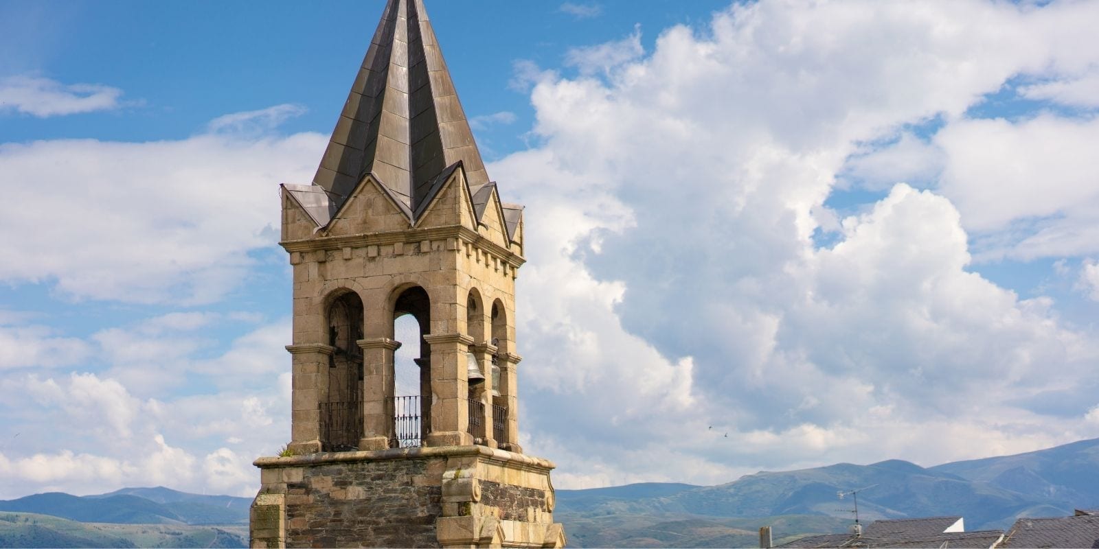 Campanile in pietra sormontato da una guglia di ardesia a Ponferrada, nella tappa da Ponferrada a Carucedo del Camino de Invierno.