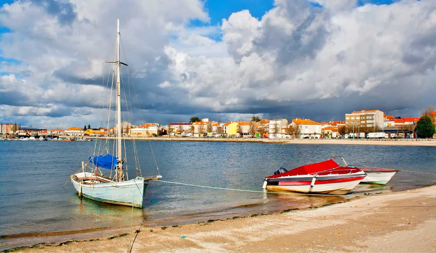 Frente marítima com barcos amarrados na margem frente à vila na etapa de O Grove a Cambados da rota do Padre Sarmiento
