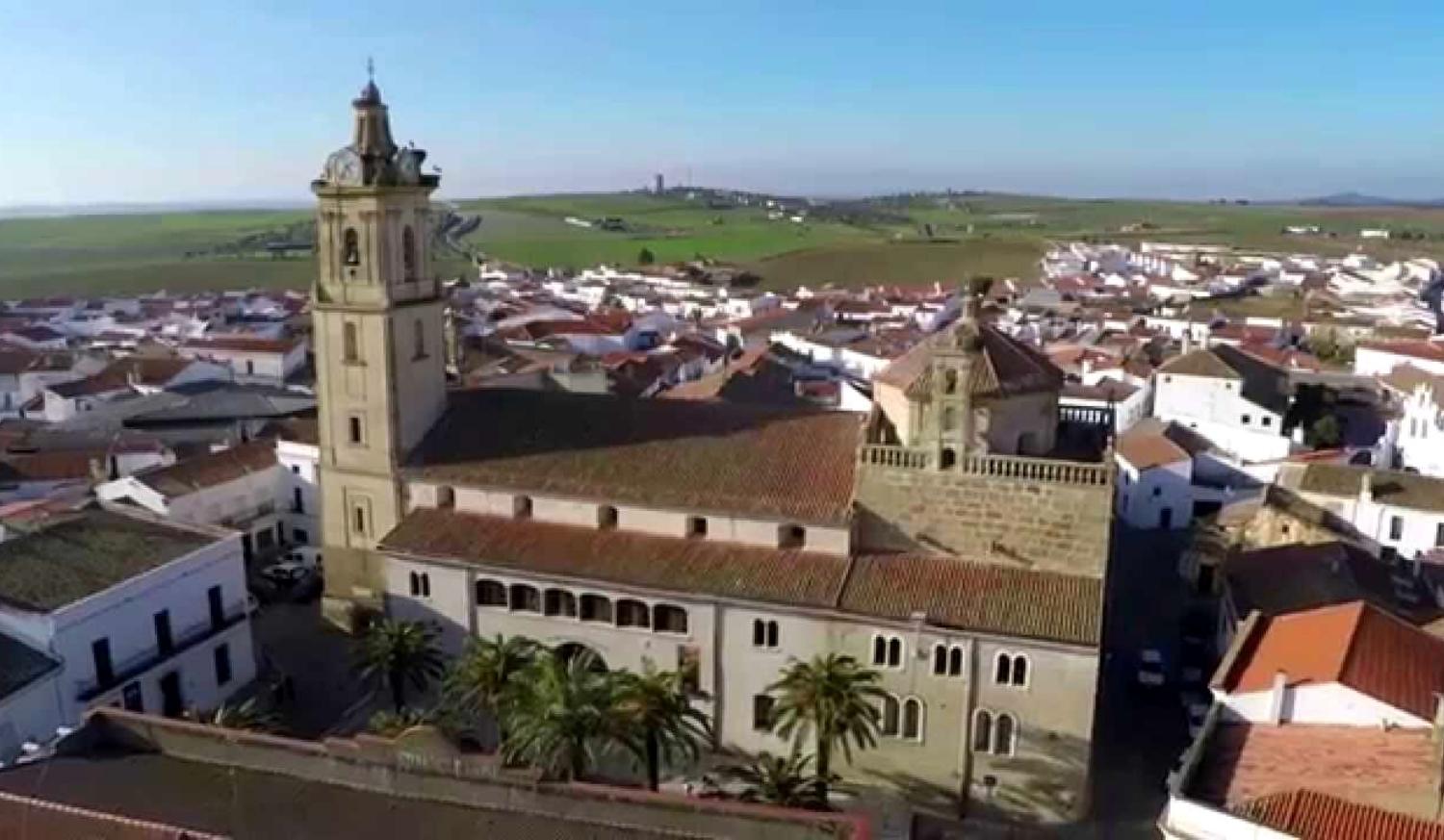 Aerial view of Fuente de Cantos with its large church and bell tower among white houses, stage to Zafra.