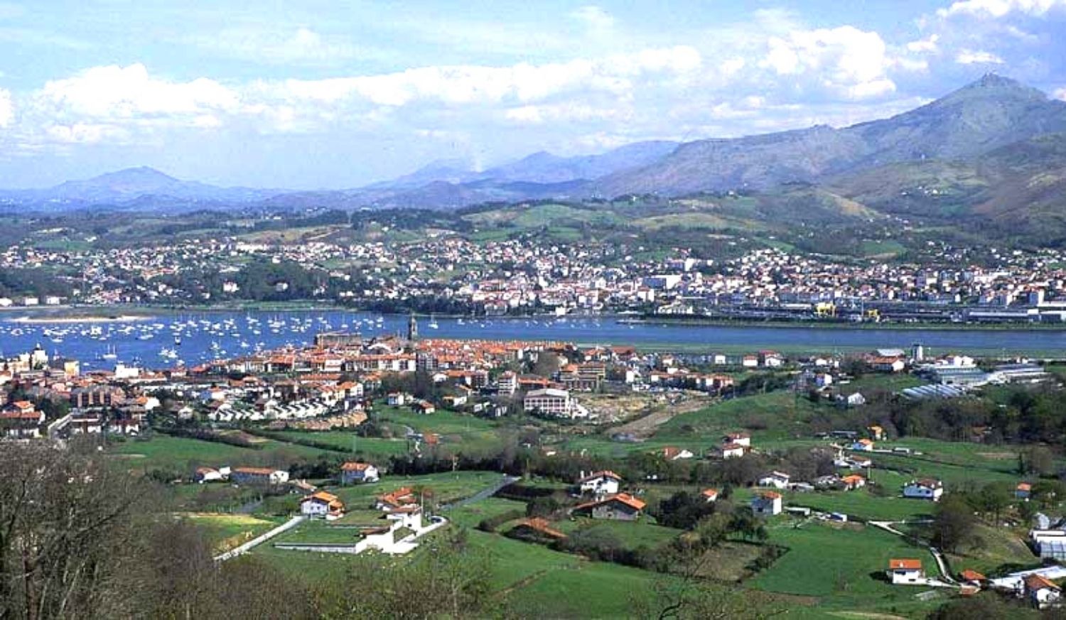 Panorama de l'estuaire de la Bidassoa avec des barques, des fermes basques et les montagnes au fond, étape d'Irún à Saint-Sébastien