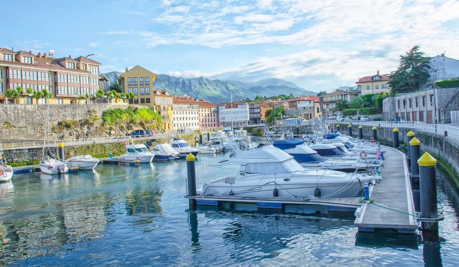 Port de plaisance de Llanes avec des bateaux amarrés et les montagnes en fond, étape De Colombres à Llanes du Chemin du Nord.