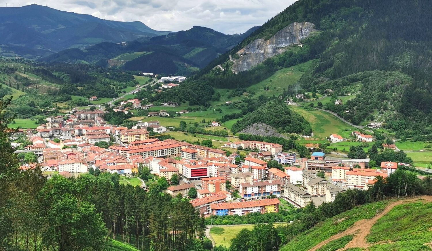 Veduta aerea del paese di Markina con tetti rossi in una valle verde tra le montagne nella tappa da Deba a Markina del Cammino del Nord.