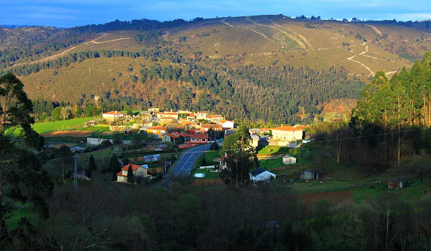 Il paese di Rodeiro tra prati e colline boscose nella tappa da Chantada a Rodeiro del Camino de Invierno.