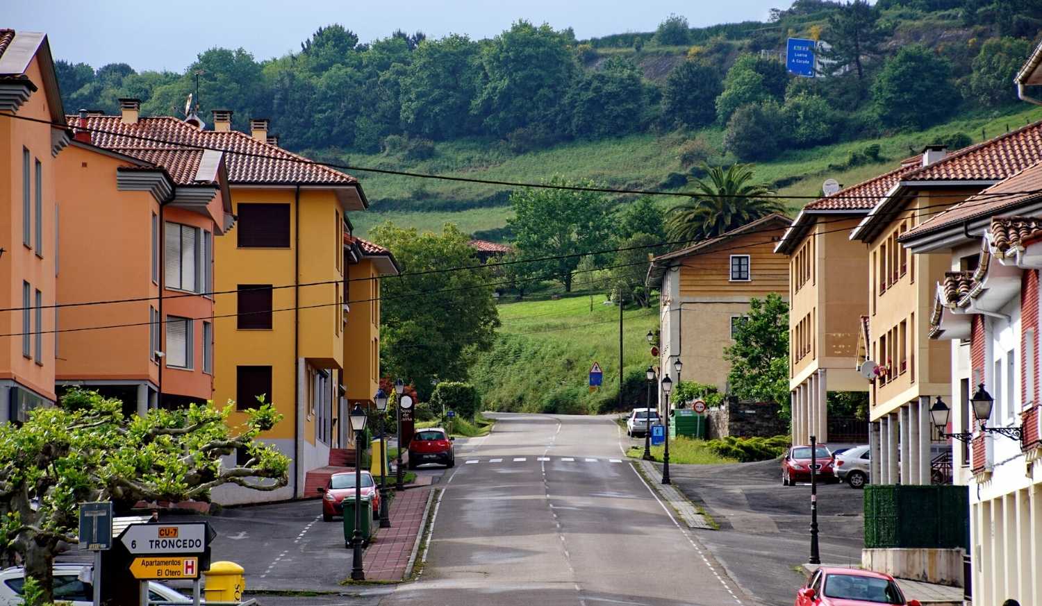 Un village ensoleillé avec maisons et prés verts sur le coteau lors de l'étape de Muros de Nalón à Soto de Luiña du Camino del Norte