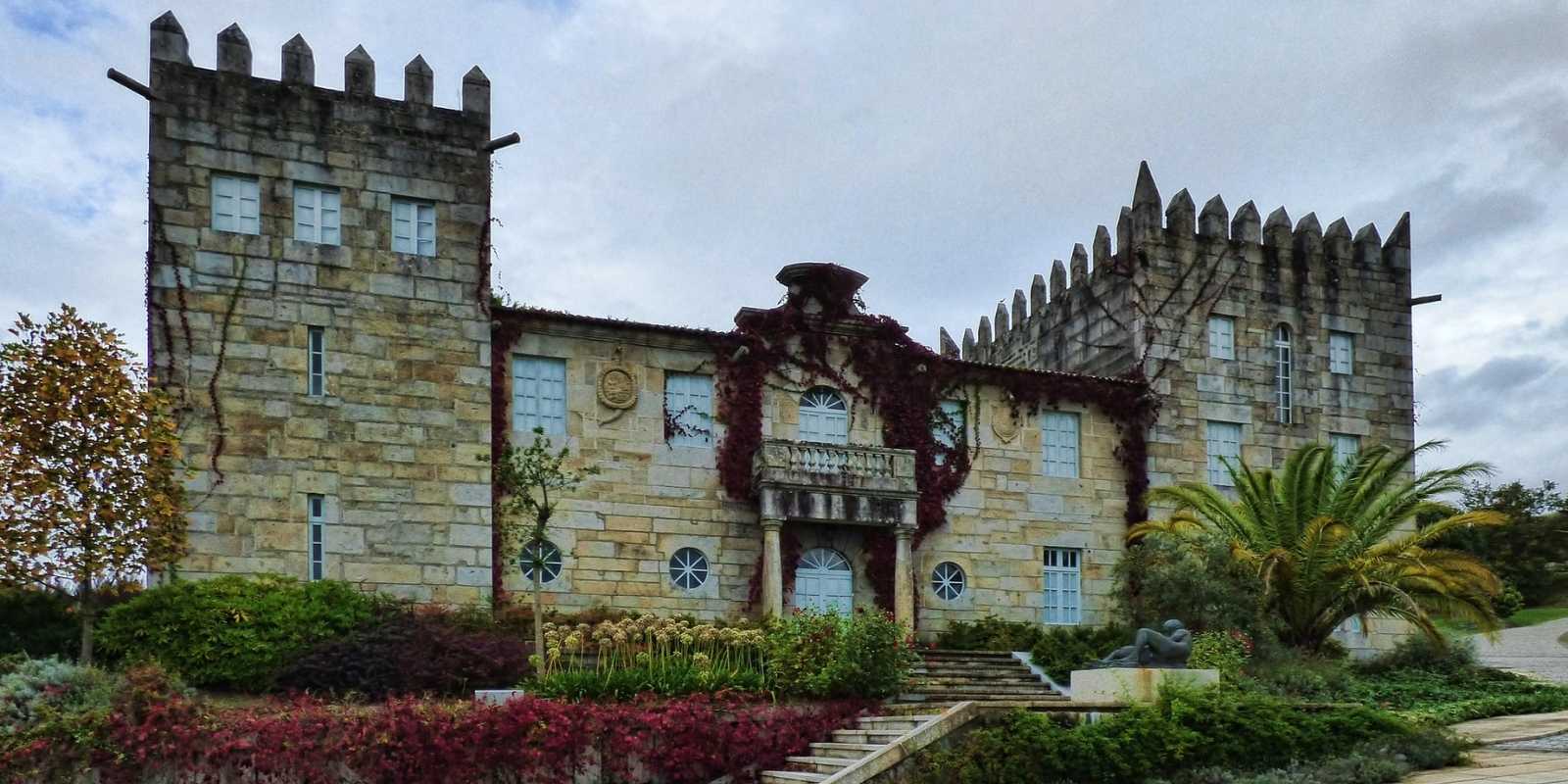 Pazo galego de pedra com torres ameadas e jardins na etapa de A Illa de Arousa a Vilanova de Arousa da rota do Padre Sarmiento
